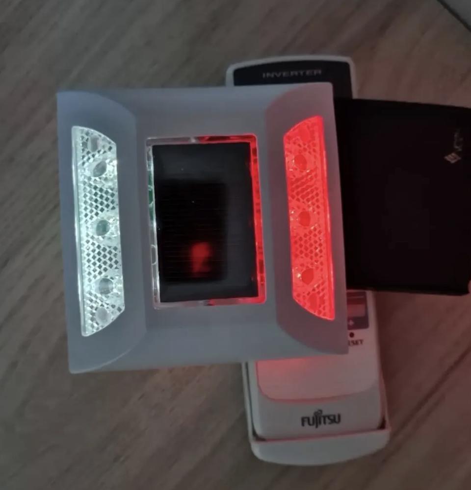 Tacha solar com LEDs brancos e vermelhos acesos